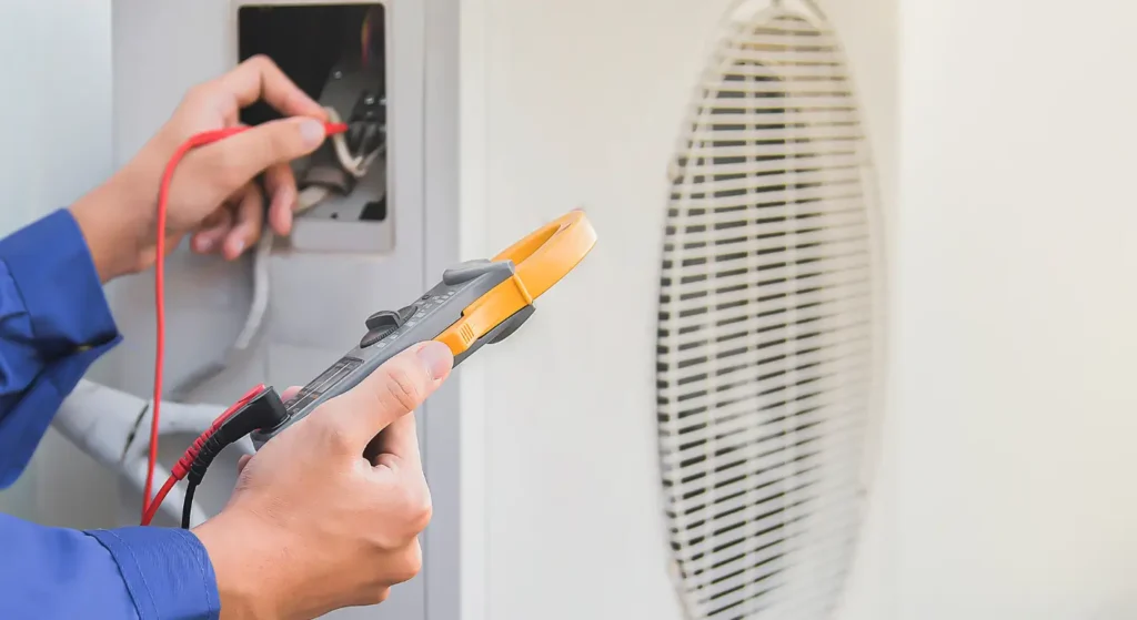 HVAC technician using digital multimeter to diagnose air conditioning electrical problems during repair HVAC service call